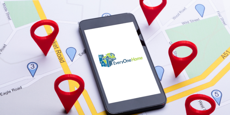 Graphic of map with red markers around it and a phone on top with the logo for Everyon Home on the screen.