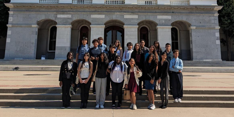 Hayward Youth Commissioners posed for a group photo in front of a large building.