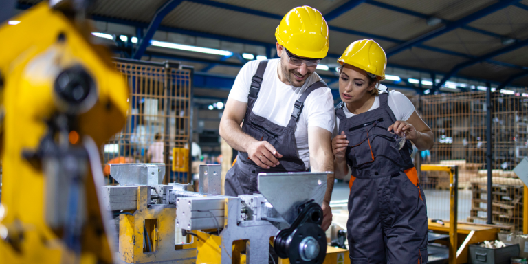 Photo of someone a person being trained on a manufacturing machine.