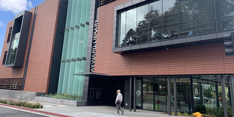 A man walking outside of the new 21st Century Library and Community Learning Center