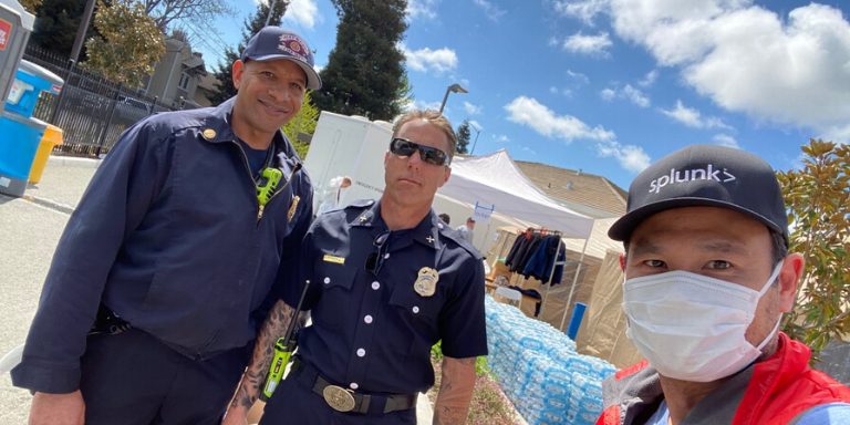 A volunteer wearing a mask with two Hayward Fire Department Personnel
