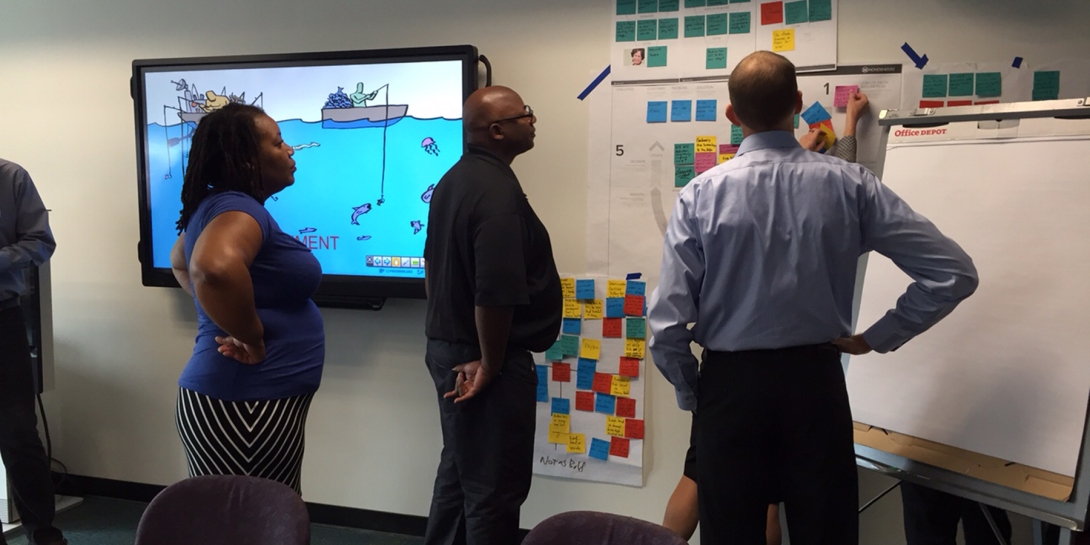 People standing in front of a white board in a conference room